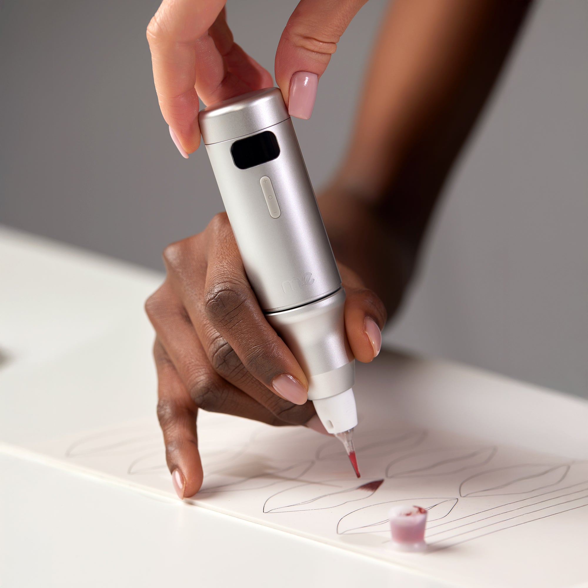 Máquina de micropigmentación inalámbrica ME™ utilizada por una artista principiante sobre piel de práctica de PMU.